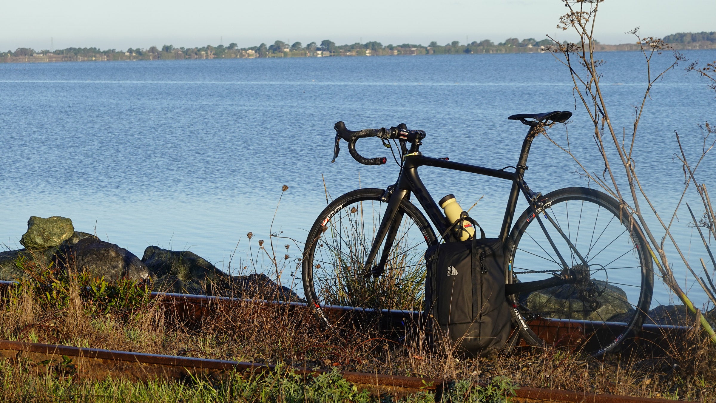 INUK CRUISER backpack beside a bicycle by the water