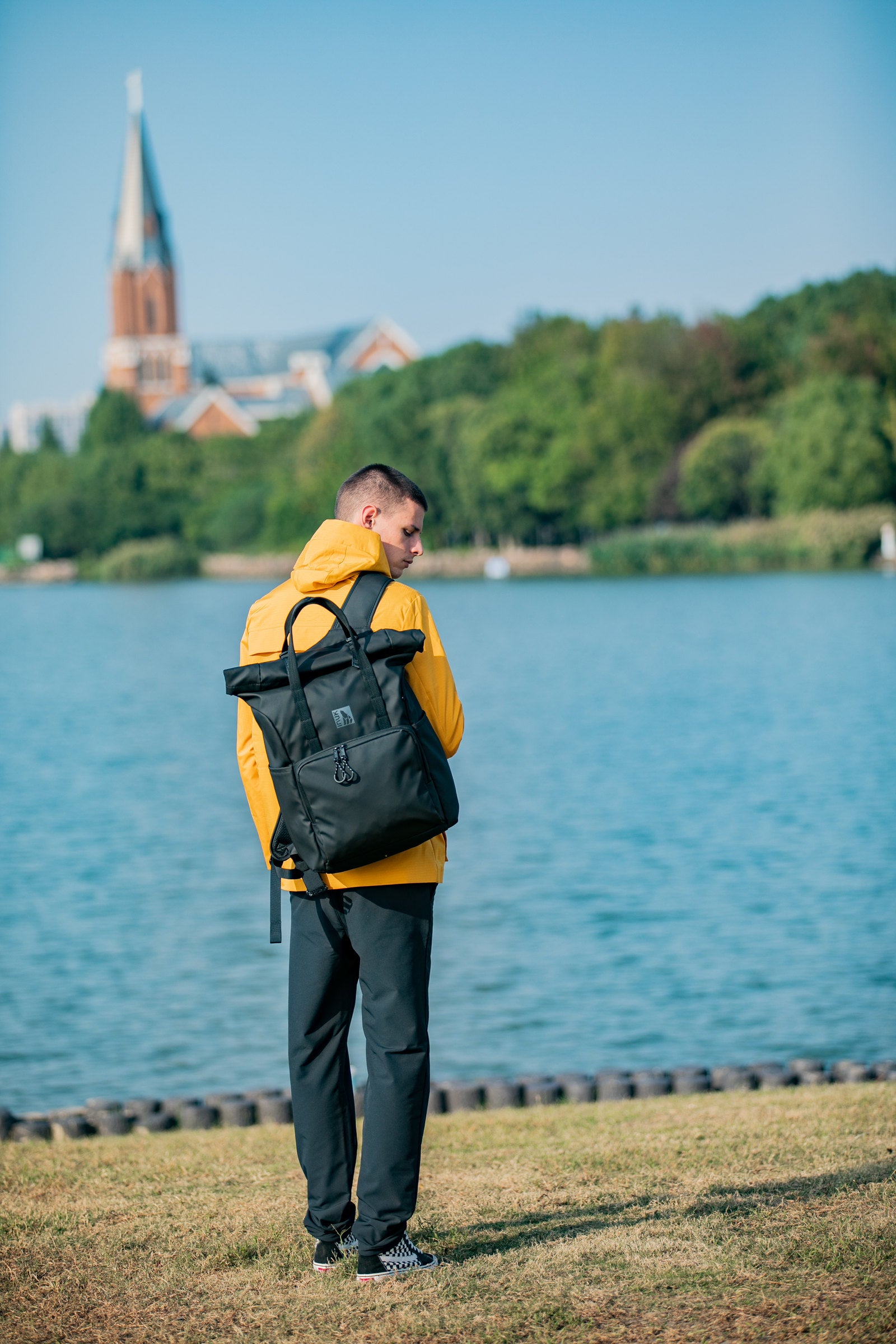 Person carrying an INUK WANDER backpack beside a lake