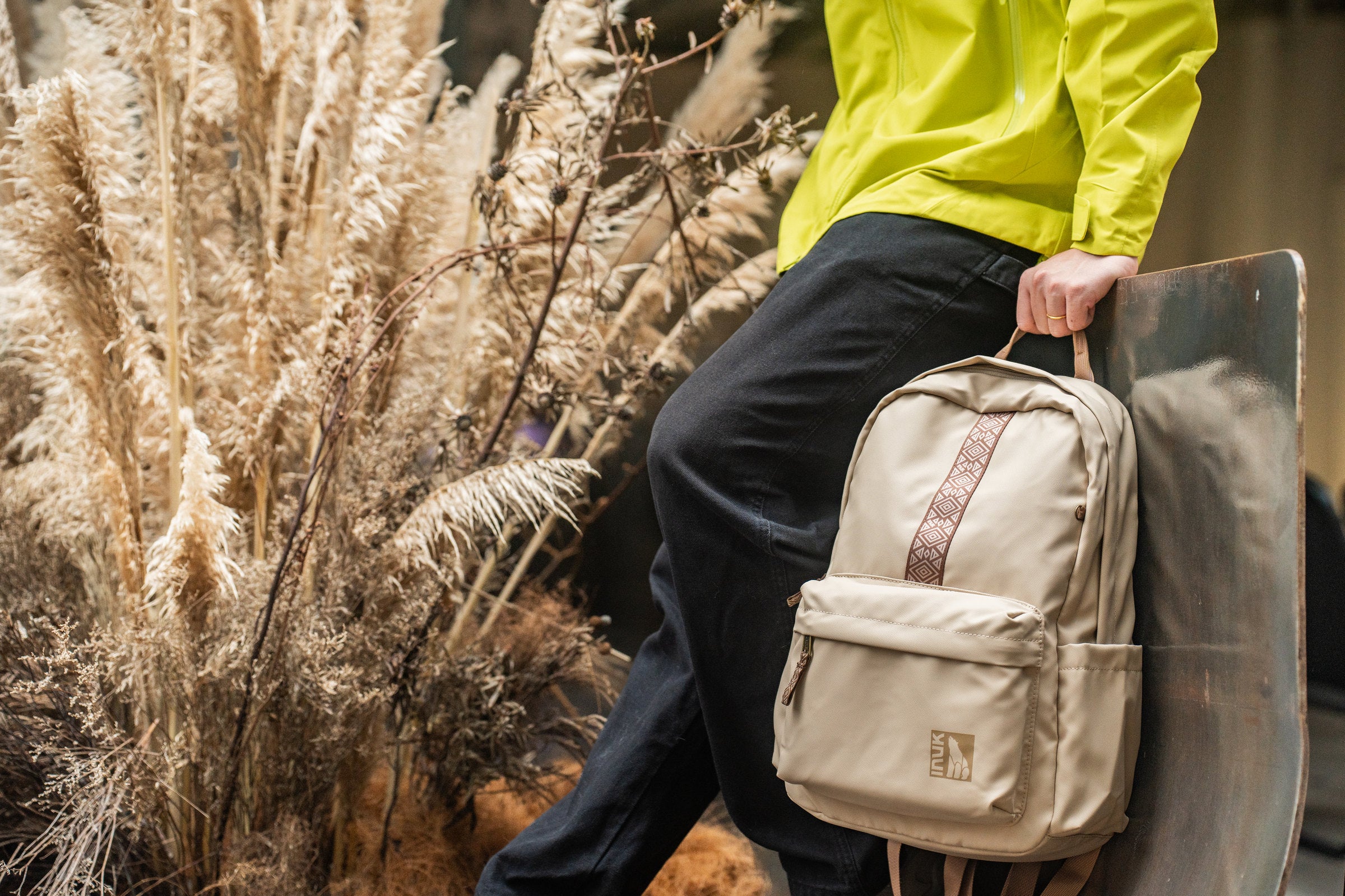 Person carrying a light gray INUK backpack outdoors